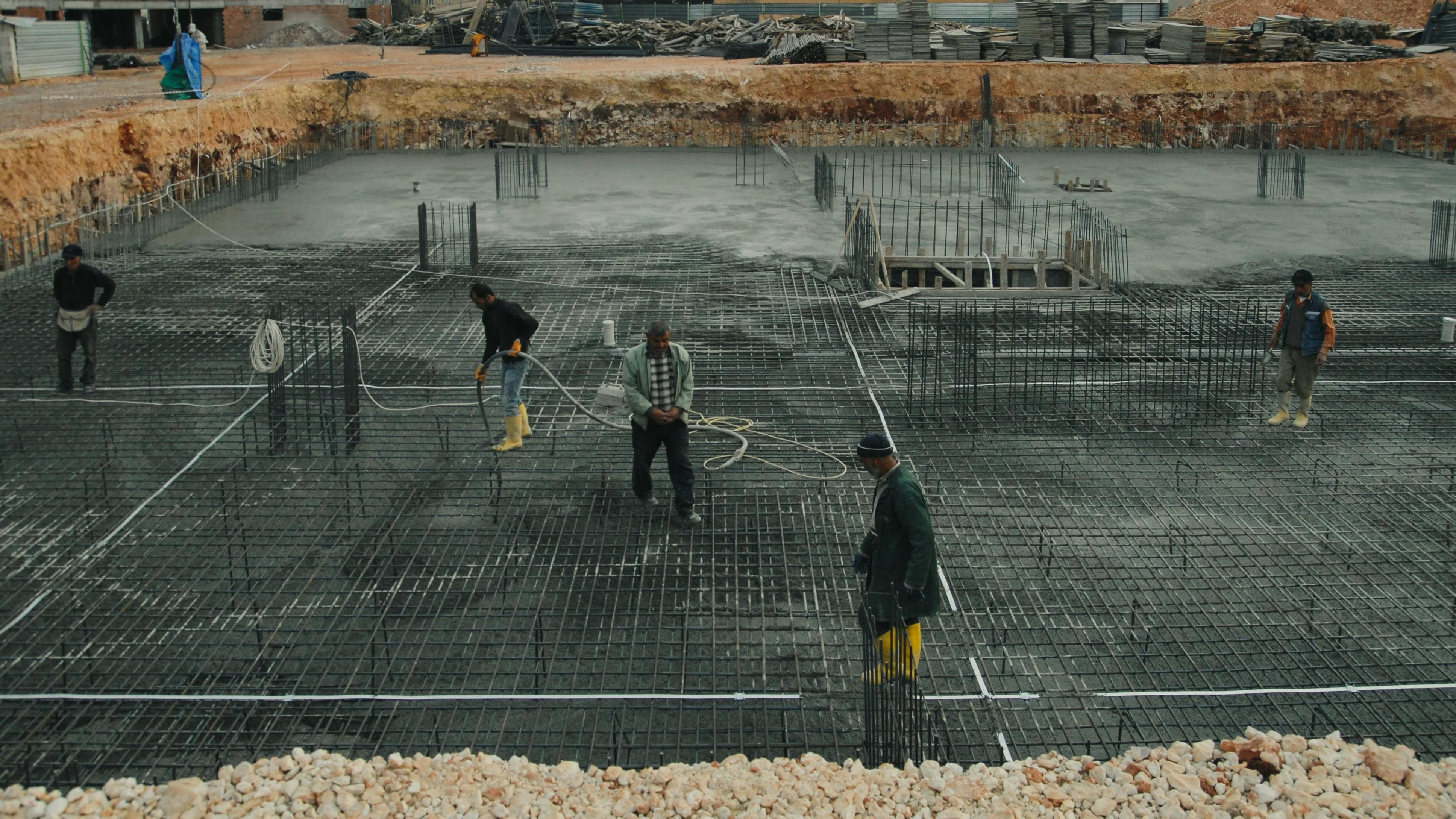 Modern commercial construction site with steel structures and workers